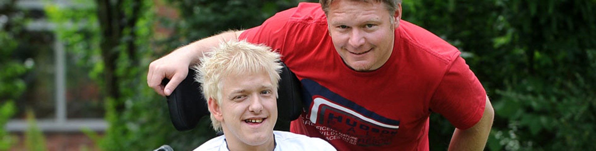 Junger Mann mit Behinderung und Caritas-Mitarbeiter (c) KNA/Oppitz