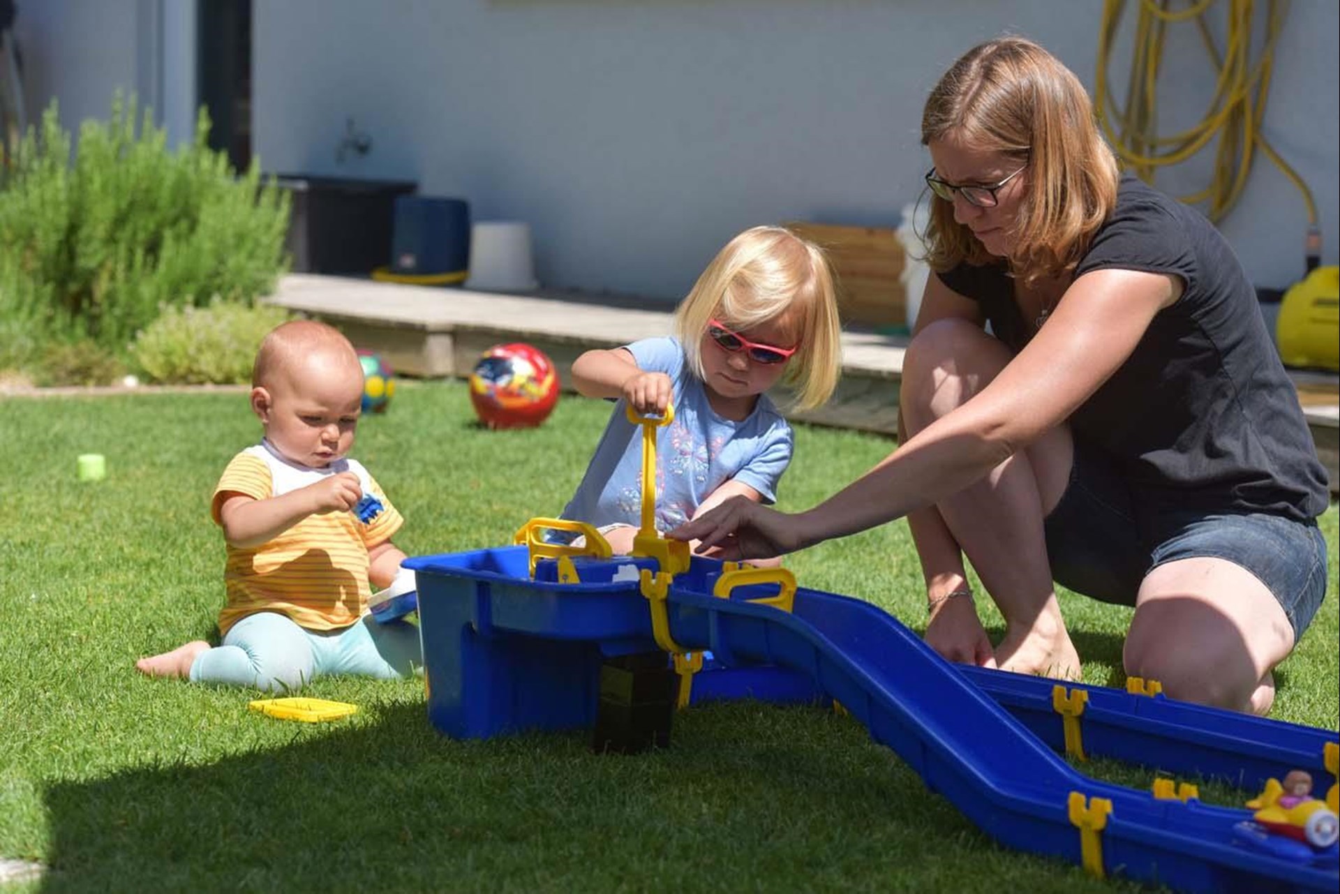 Mutter spielt mit Kindern im Garten
