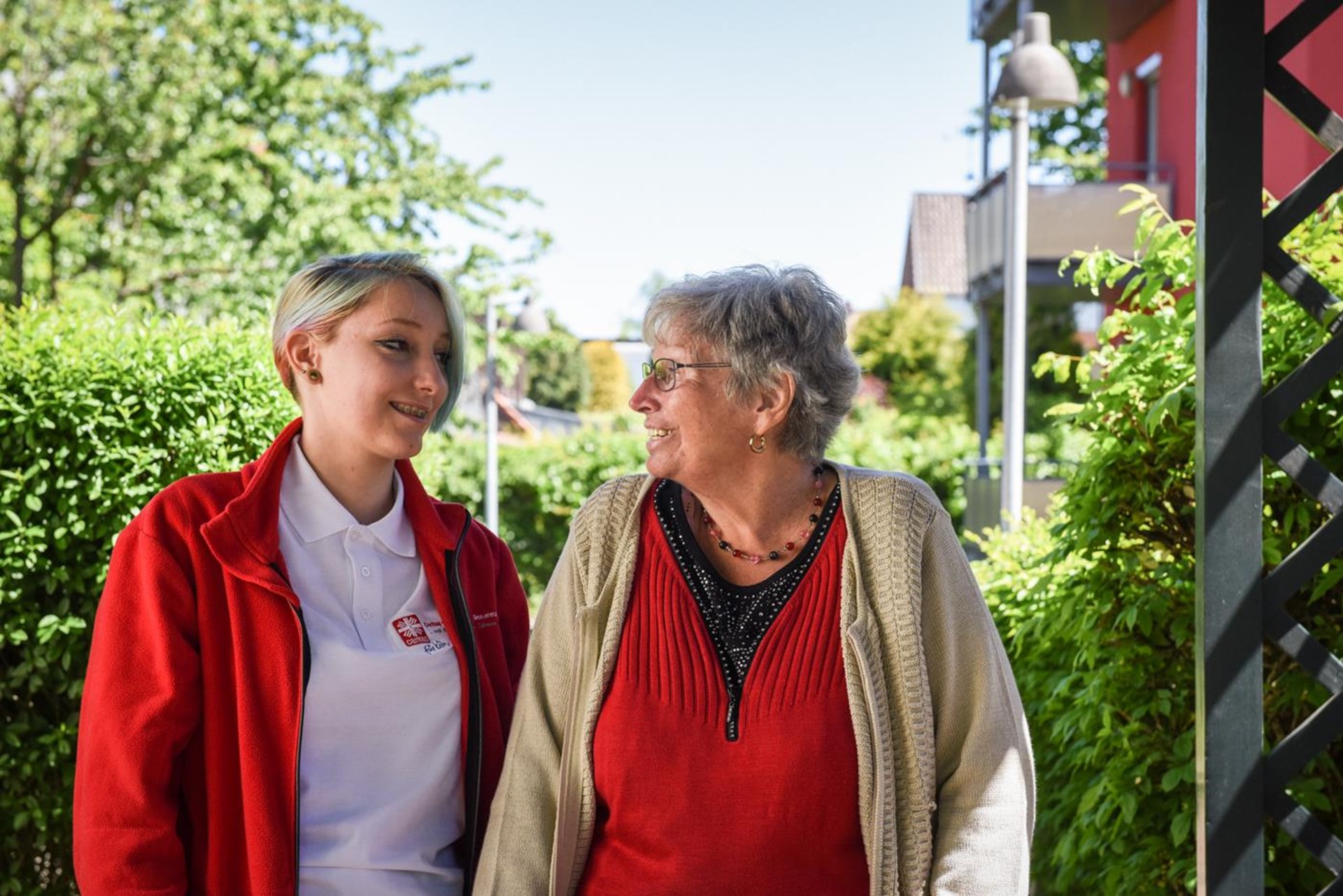 ältere Dame und Begleiterin schauen sich lächelnd an